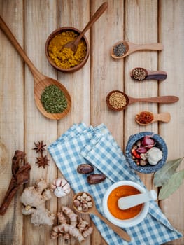 Food Cooking ingredients. Dried Spices herb cinnamon sticks,bay leaves,ginger,turmeric,nutmeg,chili,black pepper,fennel and saffron with the mortar on rustic wooden background.