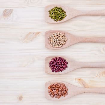 Assortment of beans and lentils in wooden spoon on wooden background.  soybean, mung bean , red bean and brown pinto beans .