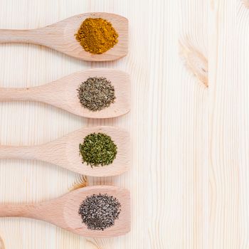 Food Cooking ingredients. Dried Spices curry powder ,black pepper ,powder,oregano and thyme in wooden spoons on rustic wooden background.