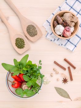 Fresh herbs and spices sage,rosemary,parsley,mint ,holy basil ,nutmeg,star anise ,cinnamon stick,oregano,thyme ,dill and chilli on wooden table. Top view with copy space.