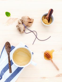 The cup of ginger tea with ginger roots , honey and mint on rustic wooden table.