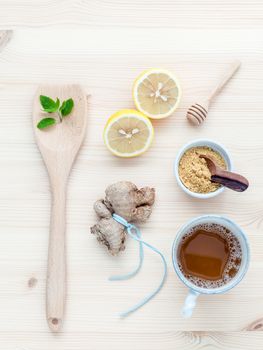 The cup of ginger tea with ginger roots , ginger powder ,lemon ,honey and peppermint on rustic wooden table.