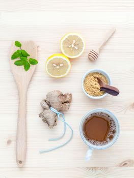 The cup of ginger tea with ginger roots , ginger powder ,lemon ,honey and peppermint on rustic wooden table.