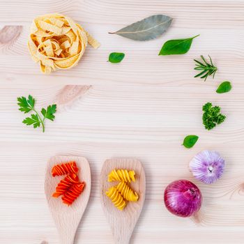 Italian food concept pasta with vegetables olive oil  with spices herbs sage,parsley holy basil and basil set up with wooden background.