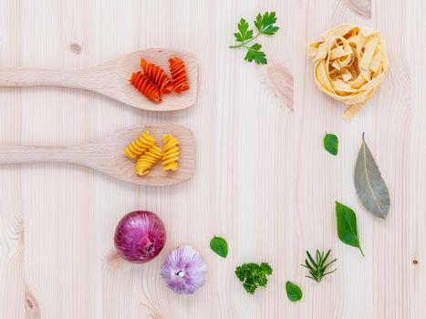 Italian food concept pasta with vegetables olive oil  with spices herbs sage,parsley holy basil and basil set up with wooden background.