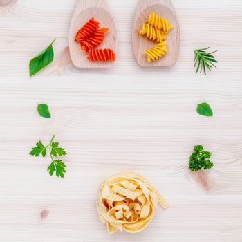 Italian food concept pasta with vegetables olive oil  with spices herbs sage,parsley holy basil and basil set up with wooden background.