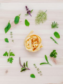 Italian food concept pasta with vegetables olive oil  with spices herbs sage,parsley holy basil and basil set up with wooden background.