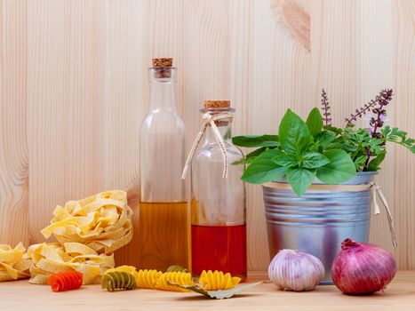 Italian food concept pasta with vegetables olive oil  with spices herbs sage,parsley holy basil and basil set up with wooden background.