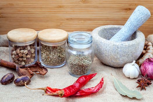 Assortment of spices ingredients of thai popular food red curry with mortar set up on wooden table.