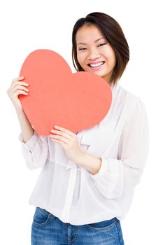 Portrait of woman holding heart shape on white background