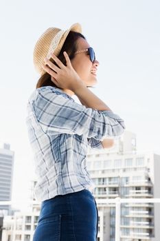 Young woman wearing sunglasses and a hat outdoors