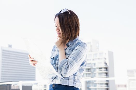 Young woman looking at map for direction outdoors