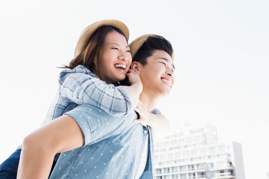 Young man giving a piggyback ride to woman outdoors