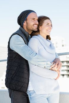 Happy young couple embracing and smiling outdoors