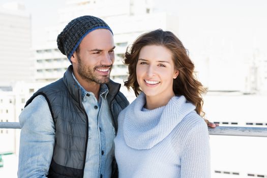 Happy young couple standing together and smiling outdoors