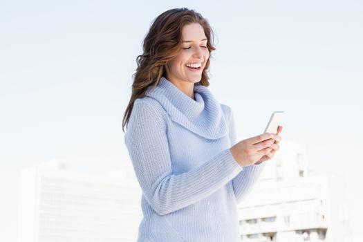 Happy young woman using mobile phone outdoors