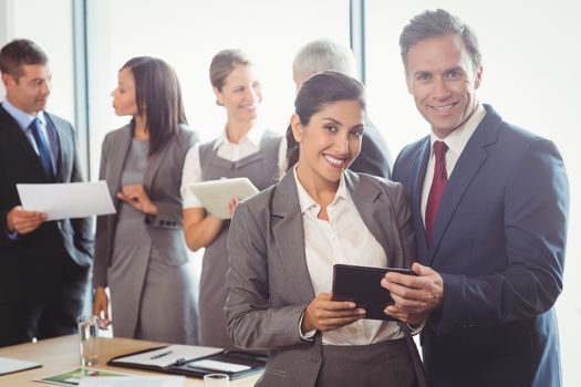 Businessman and businesswoman using digital tablet in office