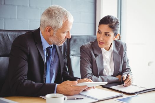 Businessman and businesswoman interacting in conference room