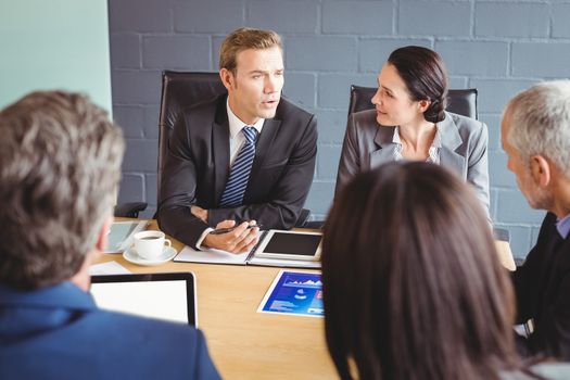 Businesspeople interacting in conference room during meeting