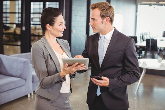 Businessman and businesswoman using digital tablet in office