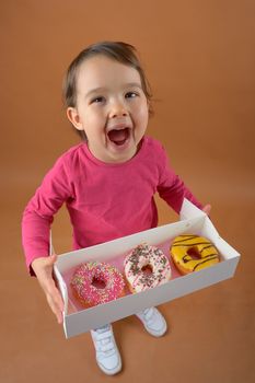 Little girl with sweet different types of donuts