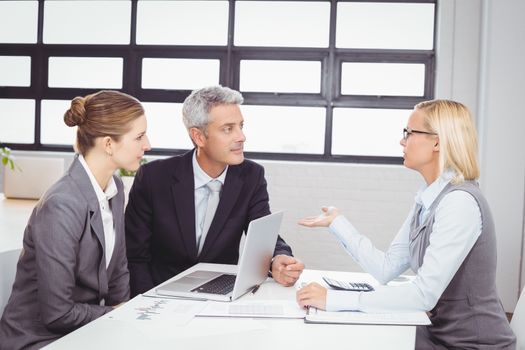 Business people discussing with client at desk in office