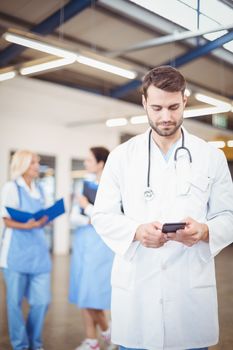 Male doctor using mobile phone at hospital
