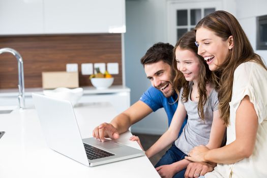 Happy family looking at laptop at home 