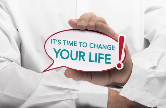Image of a man hand holding speech bubble with the text it is time to change your life, white shirt. Conceptual message for motivation and goal achievement.