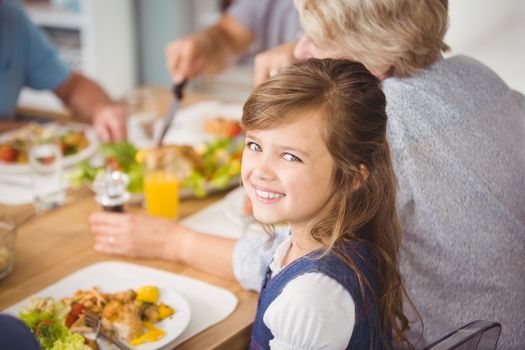 Happy girl having breakfast with family at home