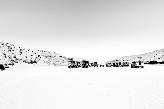 cars park on the sand at Antelope Canyon, USA in summer in black and white