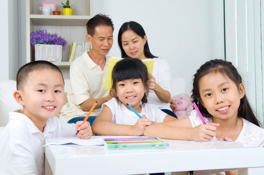 asian family doing school homework at living room