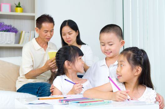 asian family doing school homework at living room