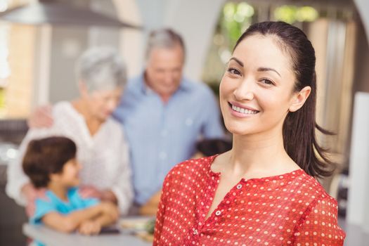 Happy woman with family in kitchen at home