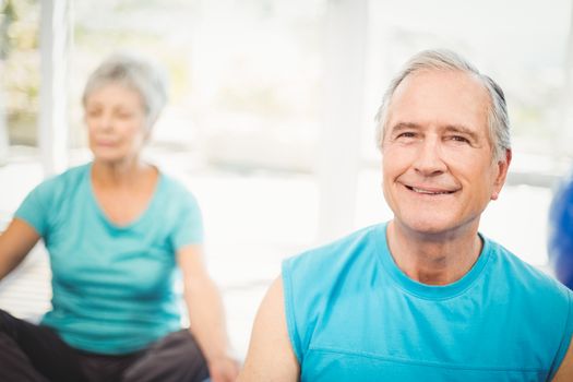Close-up portrait of senior man smiling with wife meditating at home