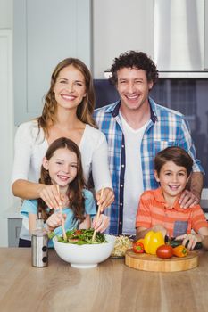 Portrait of happy family standing in kitchen at home