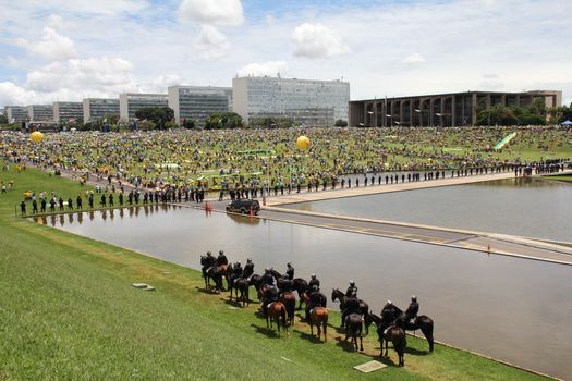 BRAZIL, Brasilia: Riot police officers on horseback stand in guard as thousands of anti-government protestors gather on the Praça dos Três Poderes (Three Powers Square), in Brasilia, during a demonstration calling for the removal of President Dilma Rousseff on March 13, 2016 . Demonstrations across the country today called for President Rousseff's exit amidst a massive corruption scandal and a deep economic recession. More than a million Brazilians have joined anti-government rallies across the country, ramping up the pressure on embattled president.