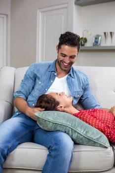 Smiling romantic couple relaxing on sofa at home