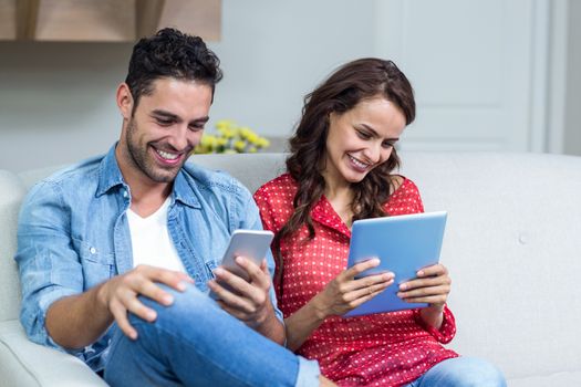 Smiling couple using technology at home