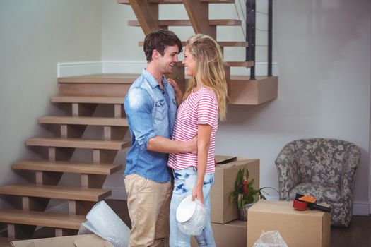 Romantic couple looking at each other while standing in new house