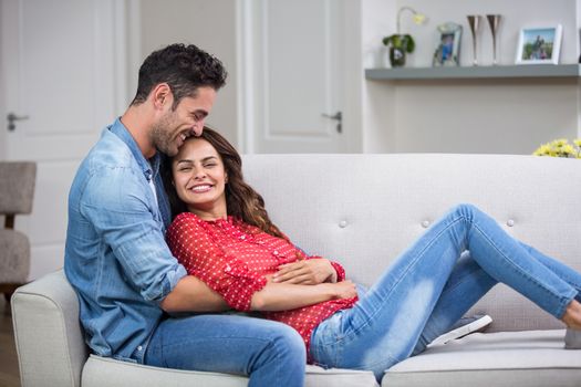  Romantic couple hugging on sofa at home