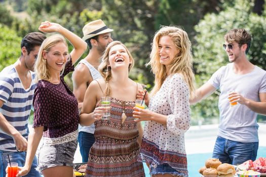 Group of friends enjoying at outdoors barbecue party near pool