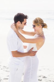 Romantic couple embracing on the beach on a sunny day