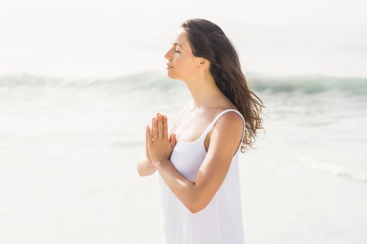 Beautiful woman in lotus position on the beach