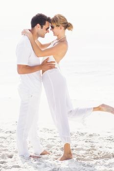 Romantic couple embracing on the beach on a sunny day
