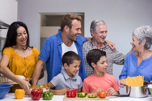 Happy family in the kitchen chopping vegetables at home