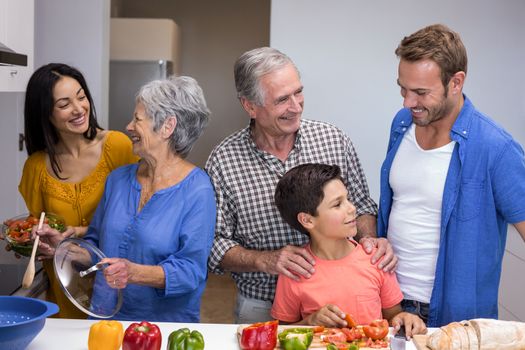 Portrait of happy family in the kitchen chopping vegetables at home