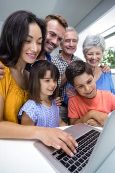 Happy family interacting using laptop in their living room