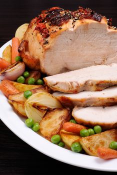 A plate of roasted turkey breast slices with vegetables