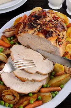 cutting roasted turkey breast slices with vegetables